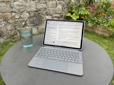 An iPad Pro in a Logitech Combo Touch case on an outdoor table